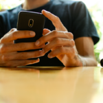 VIew of male hands posting on a smartphone