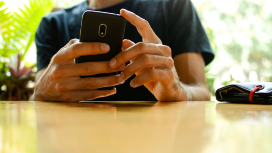 VIew of male hands posting on a smartphone