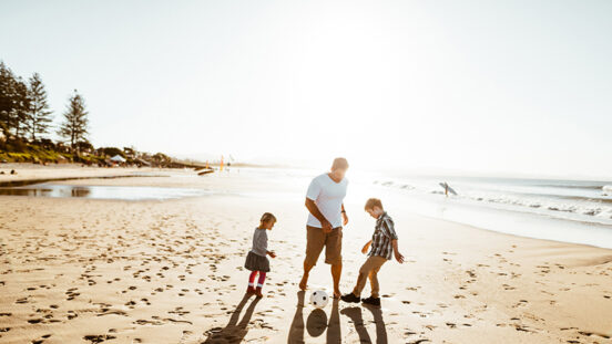 Family playing with the sand on the beach Byron Bay