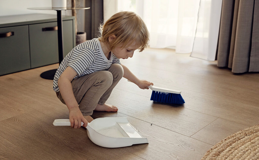 Little boy sweeping floor