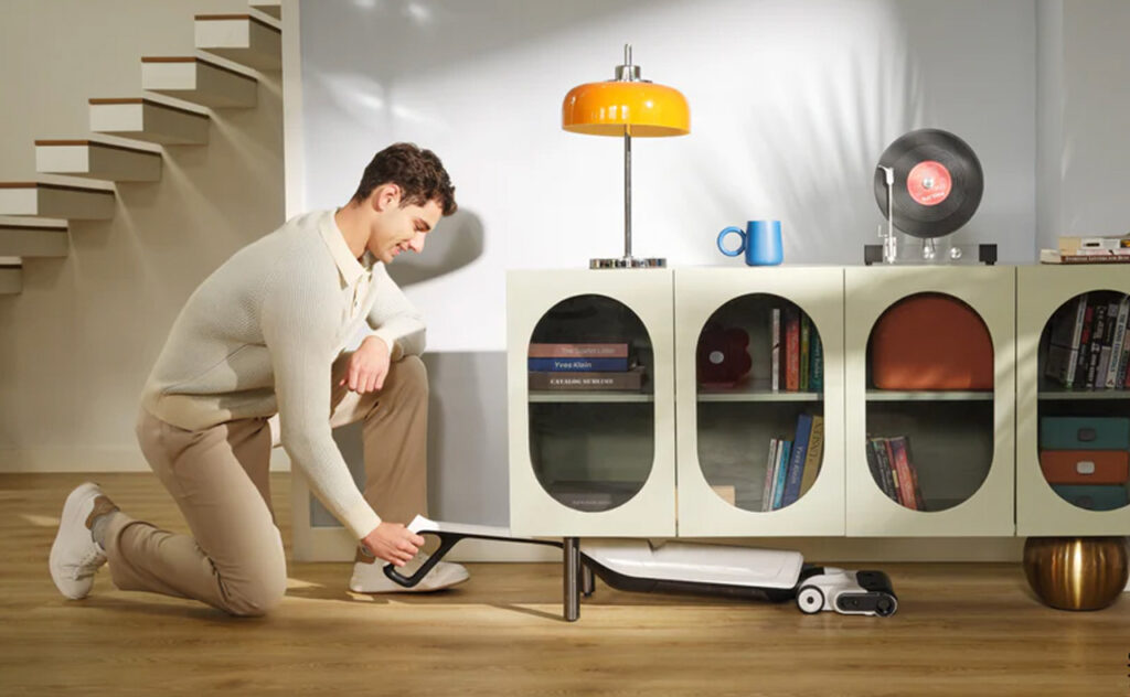 Man using Roborock Flexi Lite Wet and Dry Floor Vacuum to reach under buffet cabinet