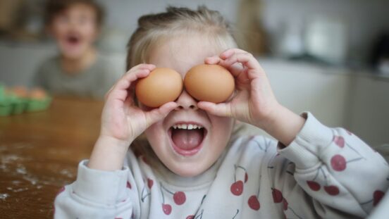 Girl holding two eggs over her eyes