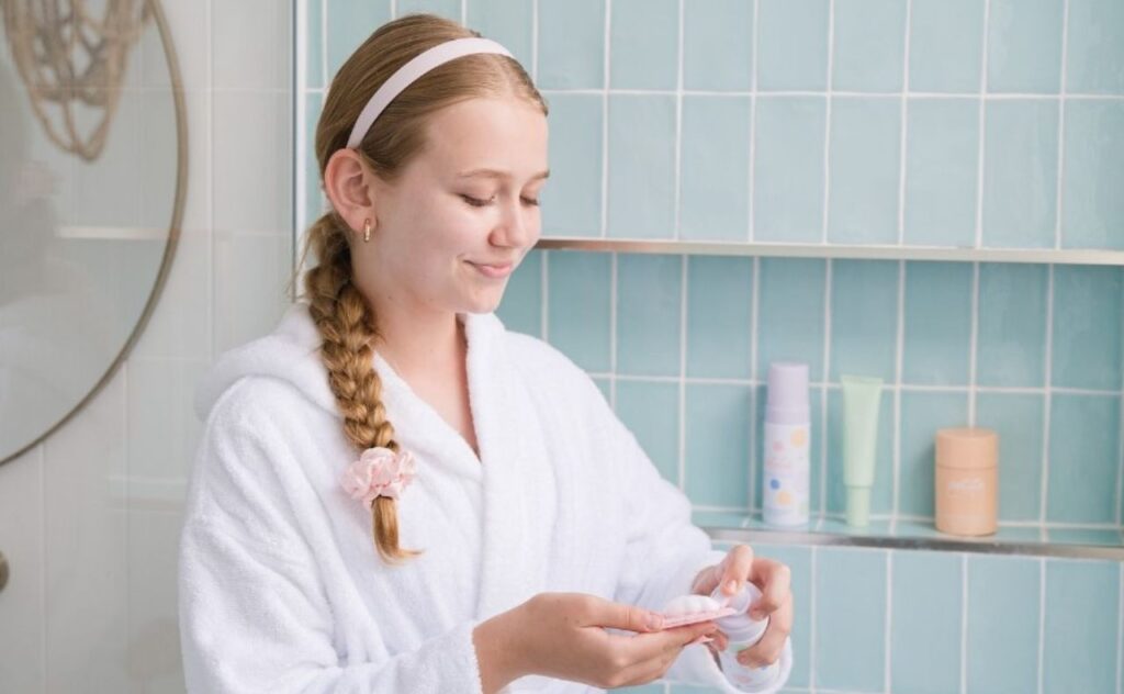 Young girl in a bathroom using skincare