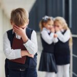 Boy feeling bullied by two girls at school.