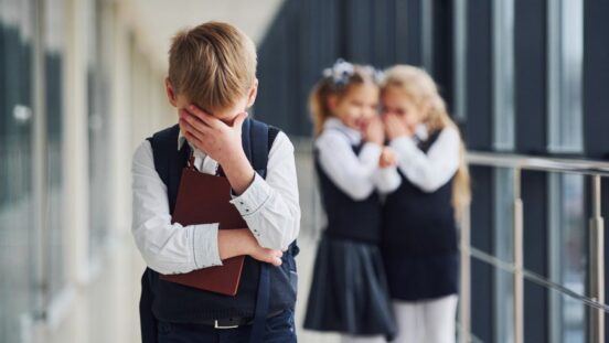 Boy feeling bullied by two girls at school.