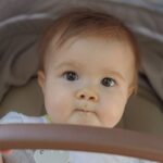 cute baby with brown eyes in a pram