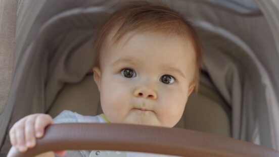 cute baby with brown eyes in a pram