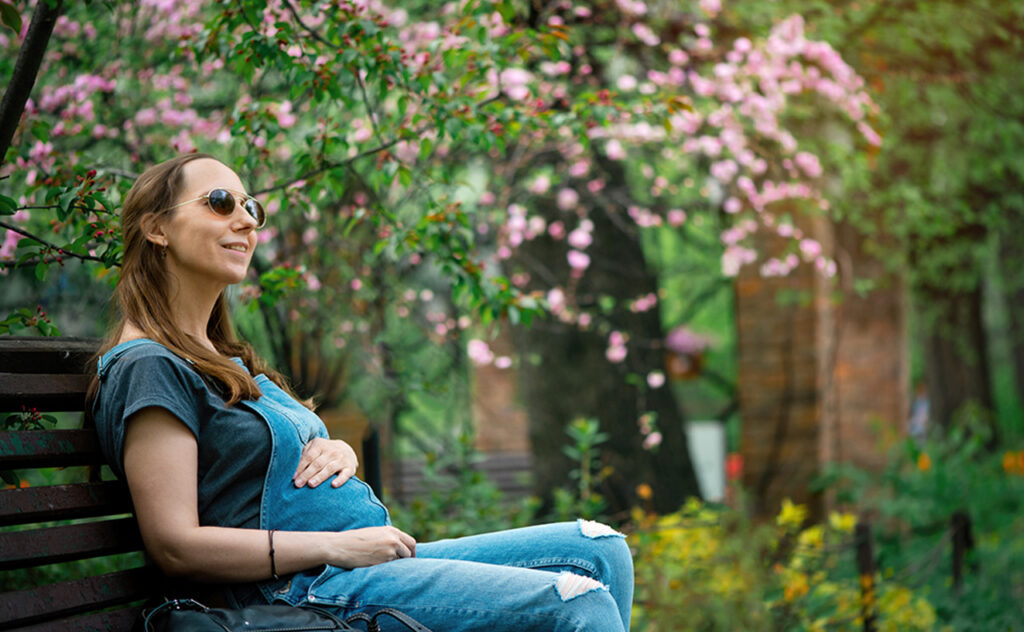 Pregnant woman enjoying springtime outdoors in nature.