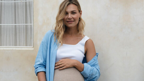 Blonde, pregnant woman modelling Bae the Label maternity fashion.