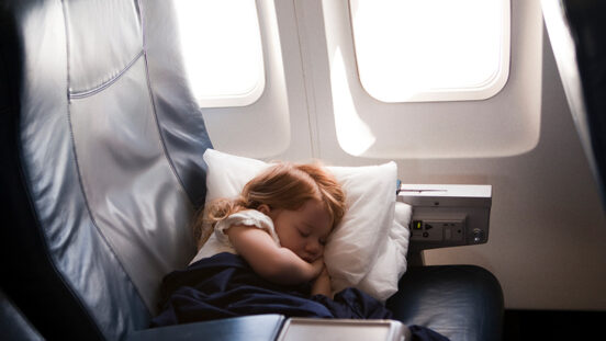 Litte girl (2-3) sleeping in business class airplane seat