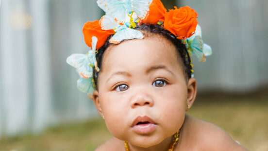 Portrait of baby girl wearing butterflies and flowers in her hair