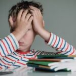 Child tired and bored of doing homework, kid stressed from learning indoors