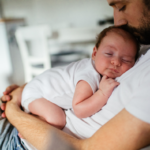 Father holding his baby boy who is falling asleep