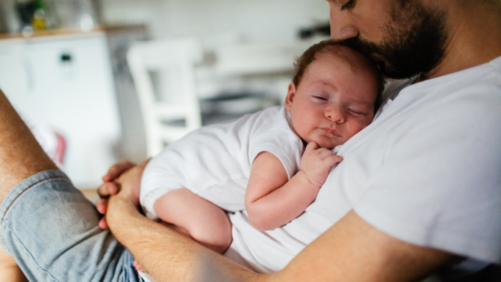 Father holding his baby boy who is falling asleep