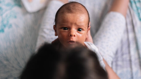 Newborn baby staring at his mother