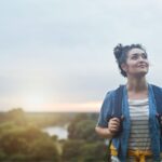 Woman bush walk/ female hiker climbing hill