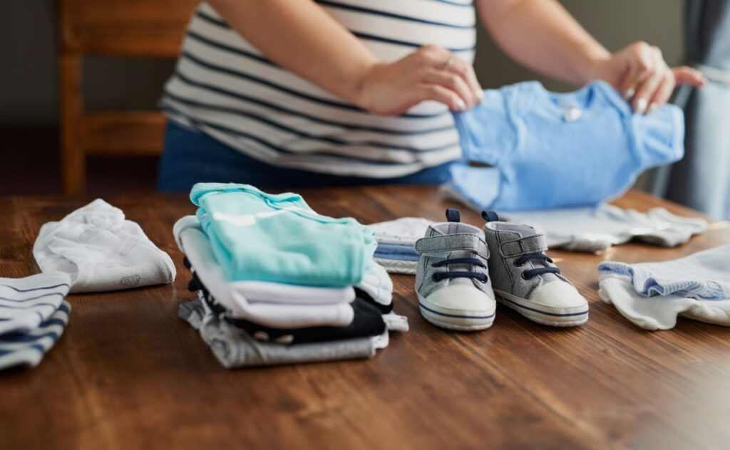 Pregnant woman folding baby clothes