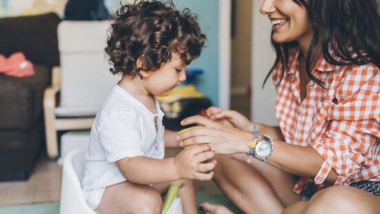 Mother training her toddler to use the potty