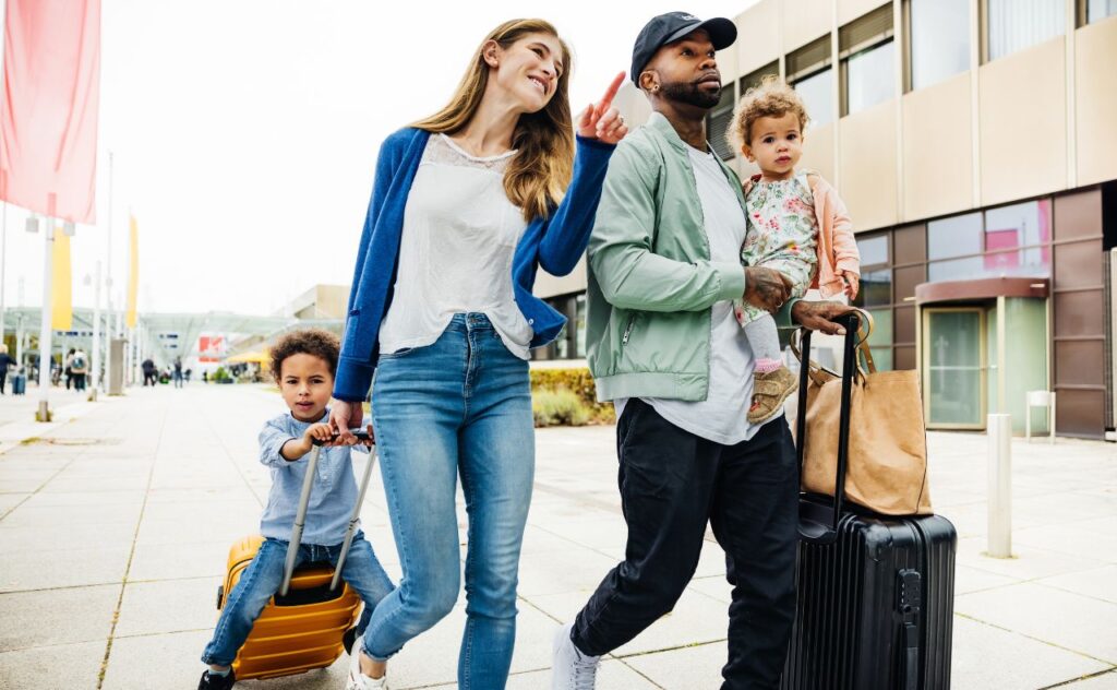 A family with two young children and their luggage are happily going on holidays