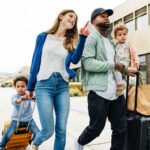 A family with two young children and their luggage are happily going on holidays