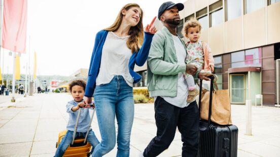 A family with two young children and their luggage are happily going on holidays