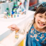 Cheerful young girl enjoying shopping in a toy shop