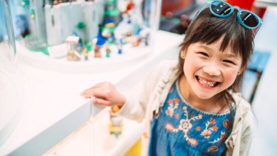 Cheerful young girl enjoying shopping in a toy shop