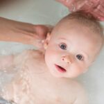 Mother washing baby in a bath